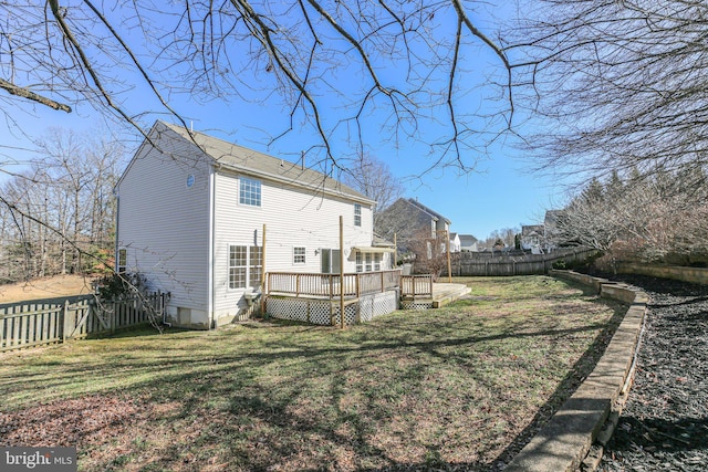 back of property with a lawn and a wooden deck