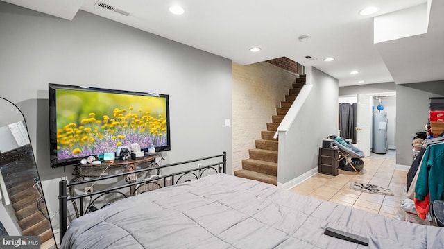 bedroom featuring light tile patterned floors and electric water heater