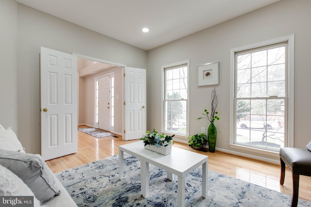 living area featuring recessed lighting, light wood-type flooring, and baseboards