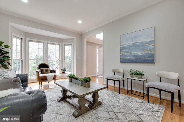 living area featuring light wood finished floors, recessed lighting, crown molding, and baseboards