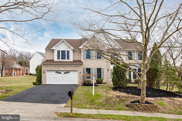 view of front facade featuring a front yard, driveway, roof with shingles, an attached garage, and brick siding