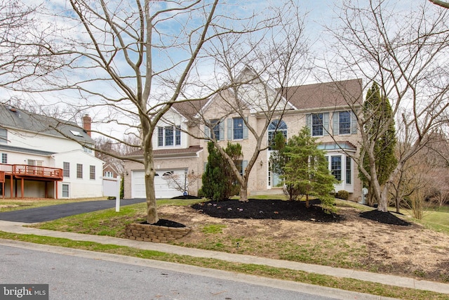 view of front of home featuring aphalt driveway, an attached garage, and a residential view