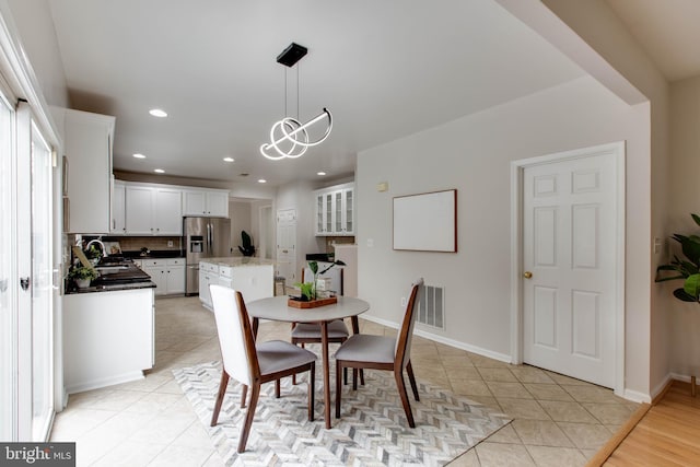 dining area with light tile patterned floors, baseboards, a notable chandelier, and recessed lighting