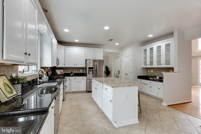 kitchen with a center island, recessed lighting, appliances with stainless steel finishes, white cabinetry, and a sink