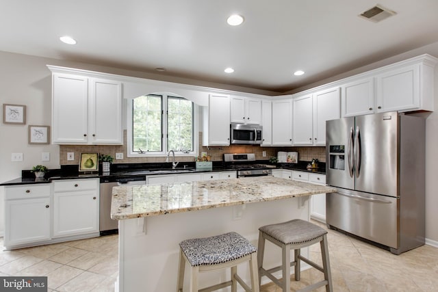 kitchen with tasteful backsplash, visible vents, appliances with stainless steel finishes, and a sink