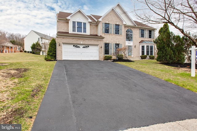 view of front of home featuring brick siding, an attached garage, and a front yard