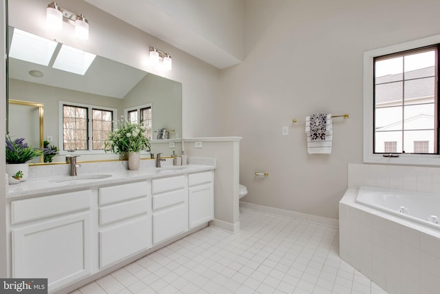 bathroom with lofted ceiling with skylight, a wealth of natural light, and a sink