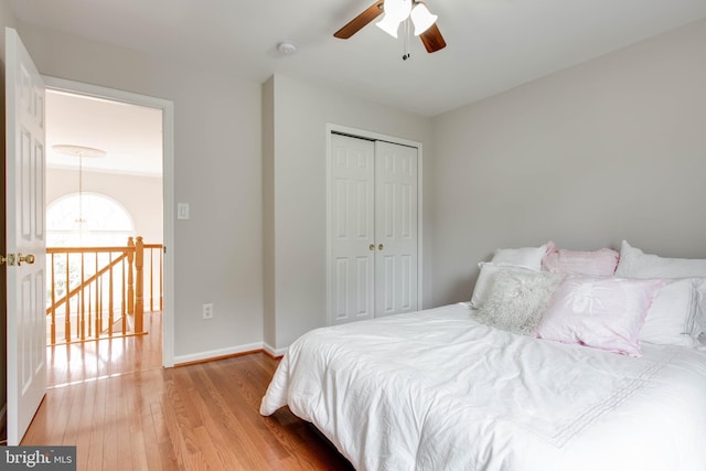 bedroom featuring a closet, ceiling fan, baseboards, and wood finished floors