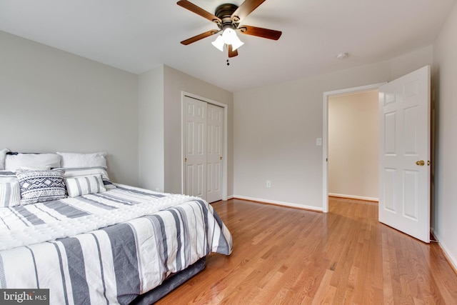 bedroom with baseboards, light wood-type flooring, a closet, and ceiling fan