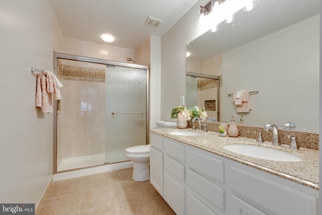 bathroom featuring tile patterned flooring, a stall shower, double vanity, and a sink