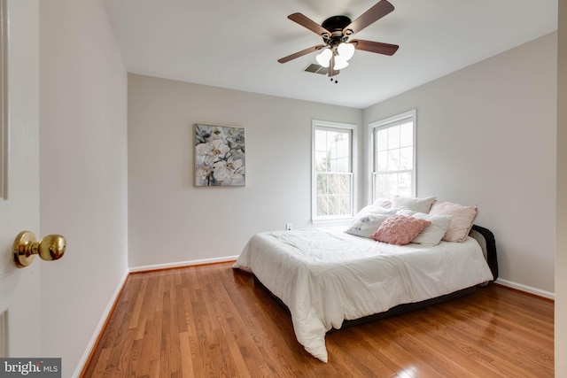 bedroom with ceiling fan, baseboards, and wood finished floors