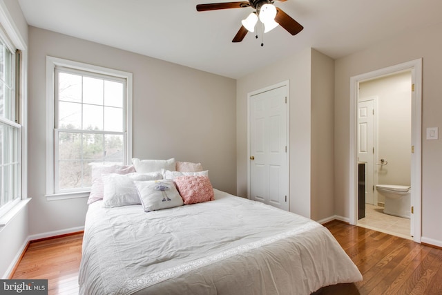 bedroom featuring ceiling fan, connected bathroom, baseboards, and wood finished floors