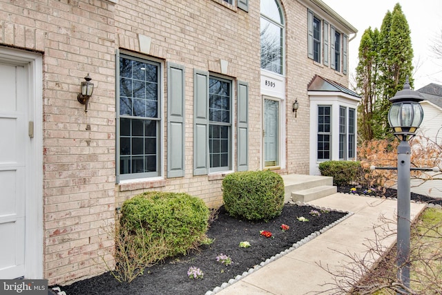 doorway to property with brick siding