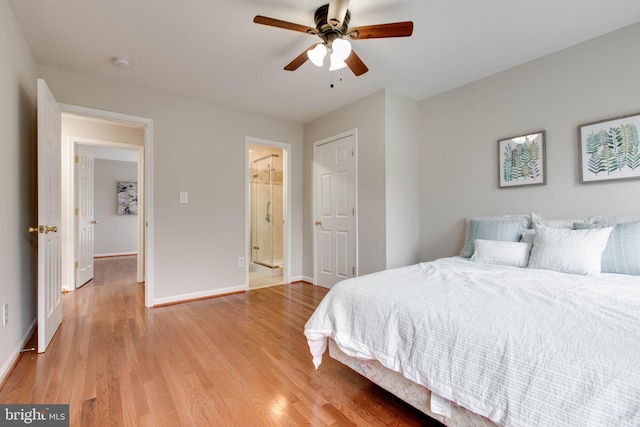 bedroom featuring ensuite bath, baseboards, light wood finished floors, and ceiling fan