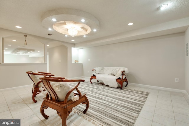 living area featuring recessed lighting, baseboards, arched walkways, and light tile patterned flooring