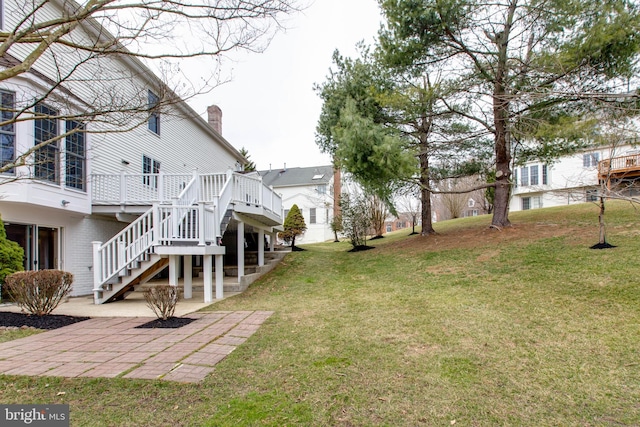 view of yard with stairway, a deck, and a patio area