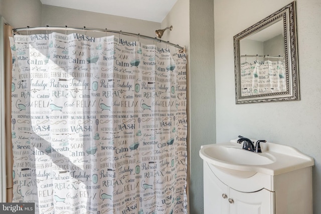 bathroom with curtained shower and vanity