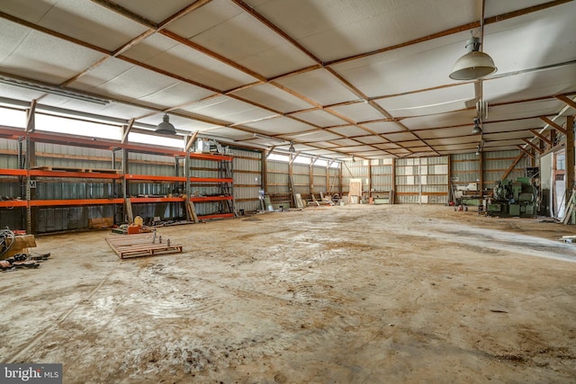 misc room featuring metal wall and unfinished concrete flooring