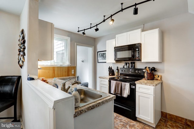 kitchen with light tile patterned flooring, sink, white cabinetry, light stone countertops, and black appliances