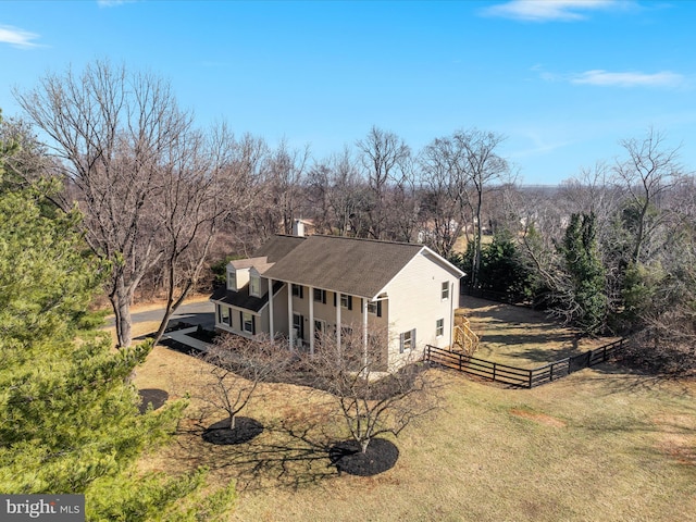 exterior space with a chimney, fence, and a yard