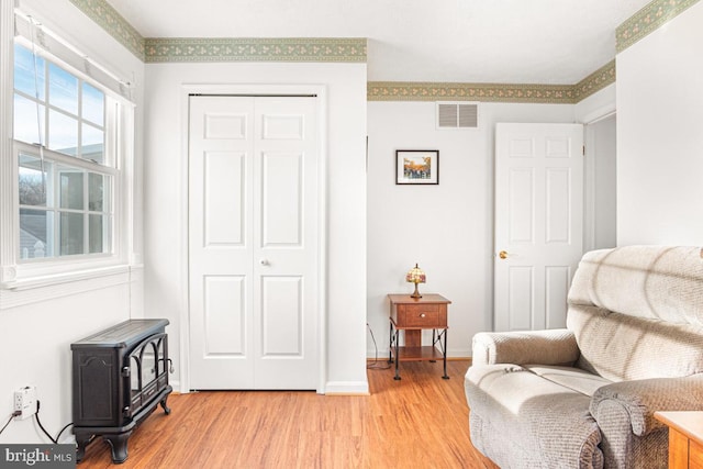 sitting room featuring light hardwood / wood-style floors and a wood stove