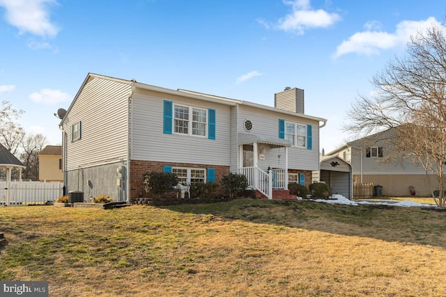 split foyer home with central air condition unit and a front lawn