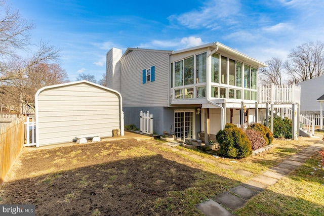 rear view of house featuring a sunroom