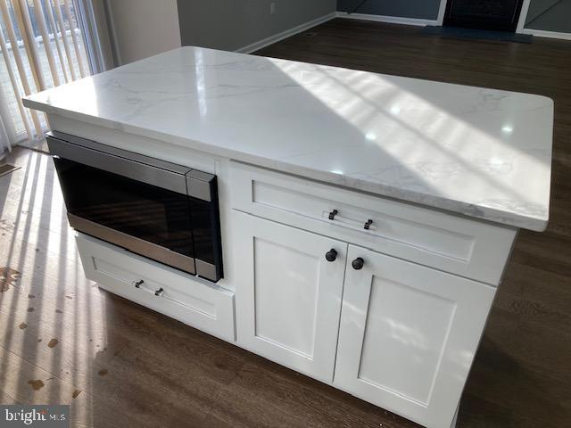 interior details featuring stainless steel microwave and wood finished floors