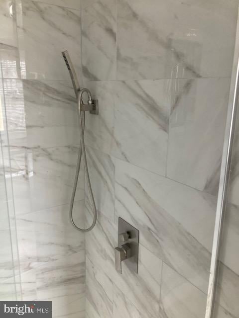 room details featuring a marble finish shower