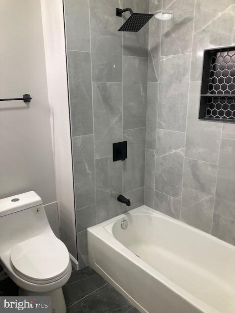 bathroom with  shower combination, toilet, and tile patterned floors