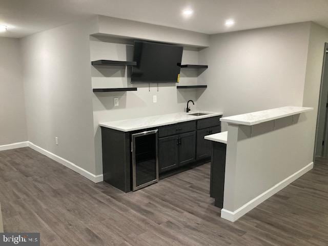 bar featuring wine cooler, recessed lighting, a sink, baseboards, and dark wood finished floors