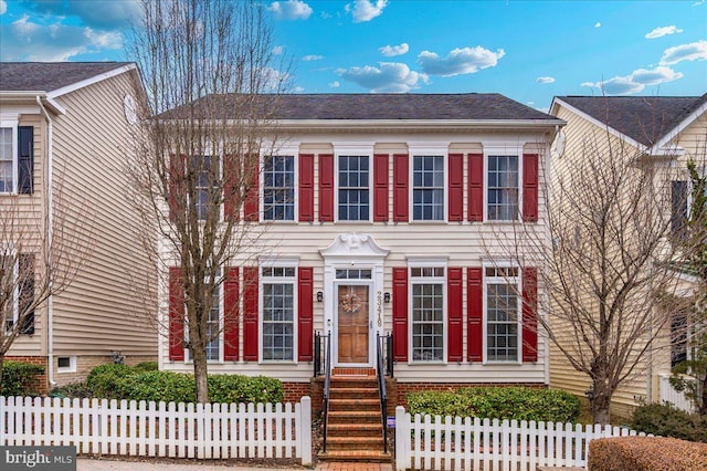 colonial inspired home featuring a fenced front yard