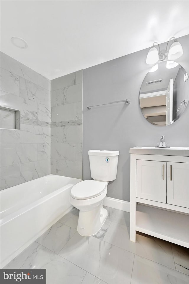 full bathroom with vanity, tiled shower / bath, and toilet