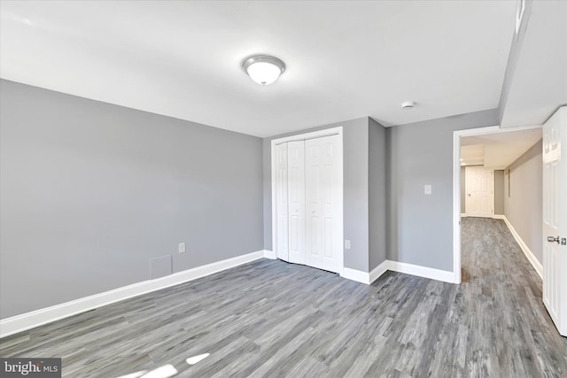 unfurnished bedroom featuring hardwood / wood-style floors and a closet