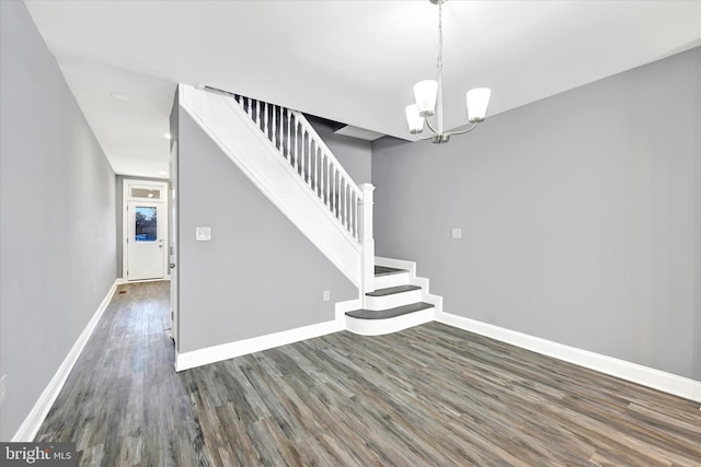 stairway with a chandelier and hardwood / wood-style floors