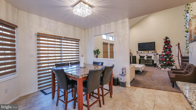 carpeted dining area with an inviting chandelier