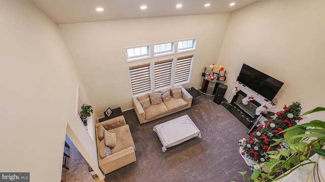 living room with dark colored carpet and a high ceiling