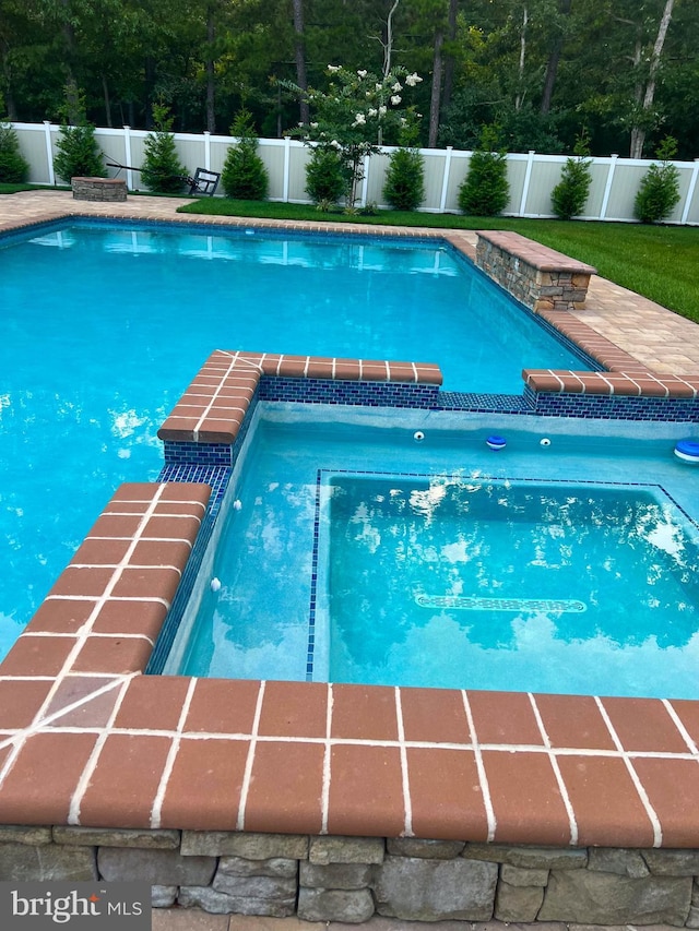 view of swimming pool featuring an in ground hot tub