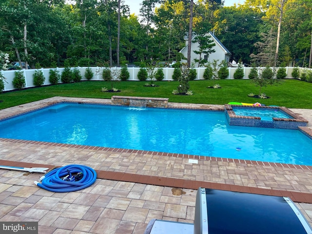 view of swimming pool featuring an in ground hot tub, pool water feature, a patio, and a lawn