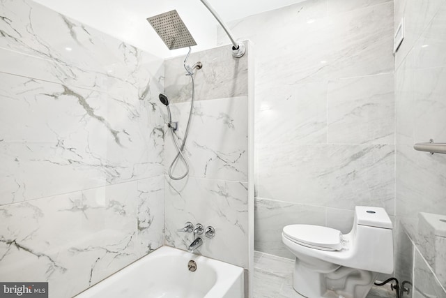 bathroom with toilet, tiled shower / bath combo, and tile walls