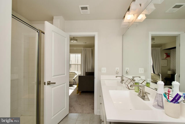 bathroom featuring vanity, a shower with shower door, and tile patterned flooring