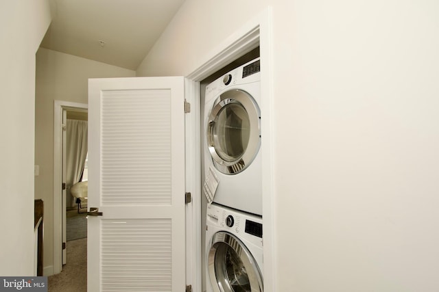 laundry room featuring stacked washer / dryer and carpet floors