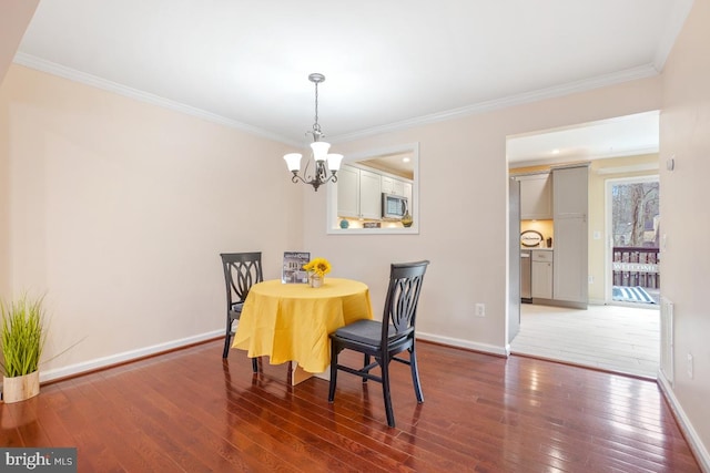 dining space featuring dark wood-style floors, baseboards, and ornamental molding