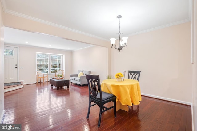 dining space with a notable chandelier, dark wood-style flooring, and crown molding