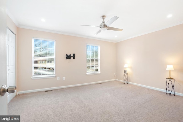 empty room with baseboards, ornamental molding, a wealth of natural light, and light colored carpet