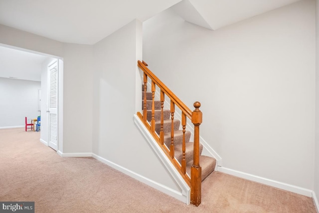 stairway featuring carpet floors and baseboards