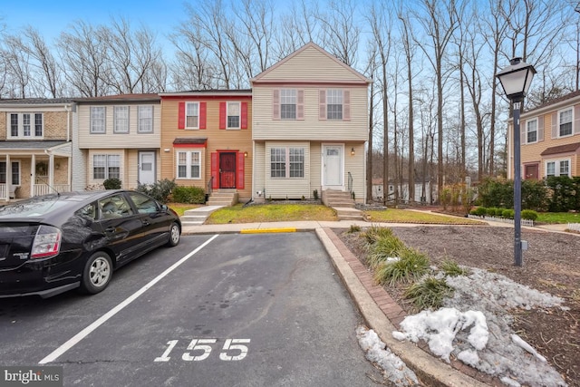 view of property featuring uncovered parking and entry steps