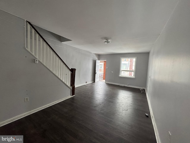 unfurnished room with dark wood-type flooring