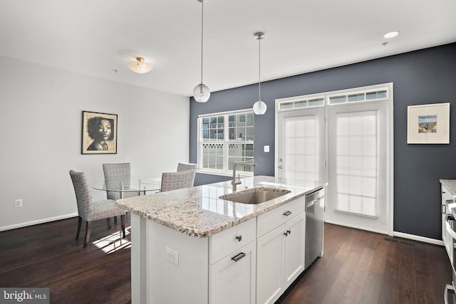 kitchen featuring pendant lighting, dishwasher, an island with sink, sink, and white cabinets