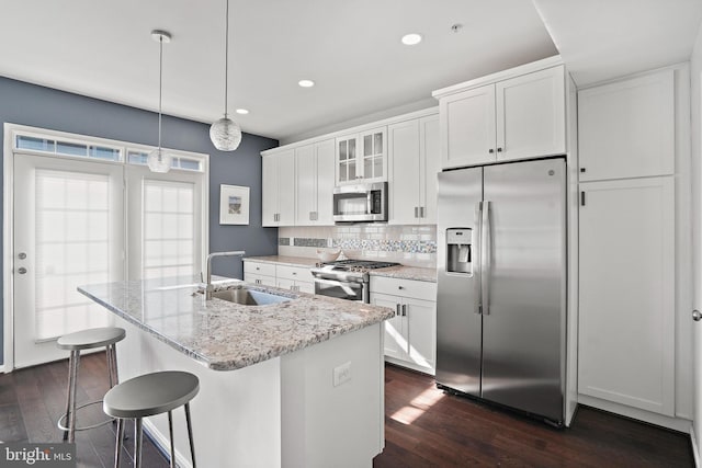 kitchen featuring a kitchen island with sink, sink, white cabinetry, and appliances with stainless steel finishes